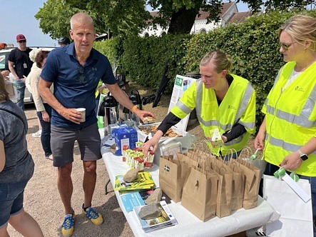 Fika vid ett bord, personer tar en bulle