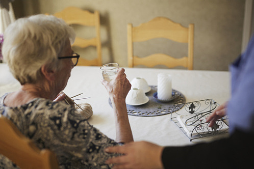 Äldre kvinna som får hjälp i hemmet av hemstjänst.