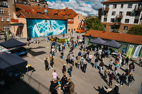 Besökare promenerar bland muralmålningar och konstinstallationer i kvarteret Gjutaren under Artscape-festivalen i Eslöv.