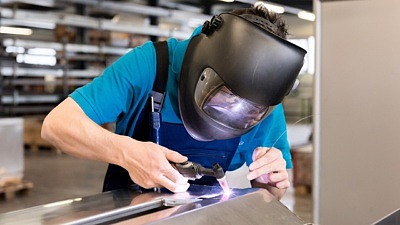 Person med skärm på huvudet som arbetar i fabrik