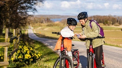 två personer står bredvid sina cyklar och läser en karta