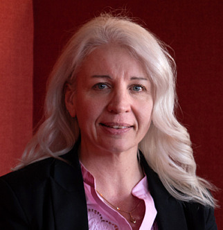 Kvinna i långt blont hår, klädd i svart