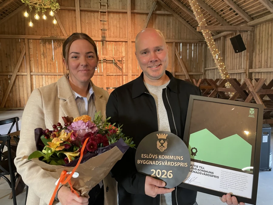 En glad kvinna och en glad man med blommor i famnen