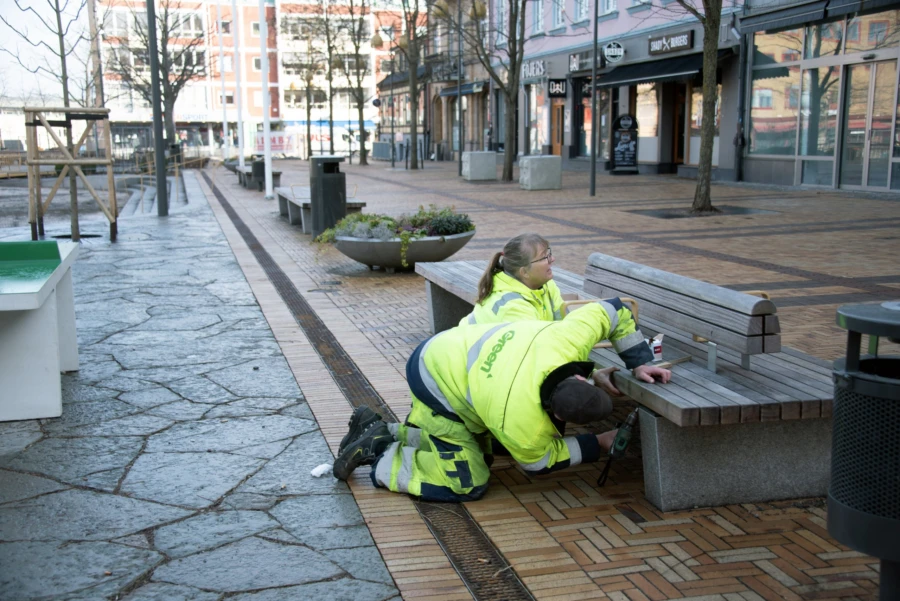 Diana G&aring;rdenhag och Lars Nilsson fr&aring;n Green Landscaping s&auml;tter upp sensorer under parkb&auml;nkar p&aring; Stora torg.