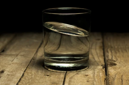 Ett glas med vatten står på ett bord