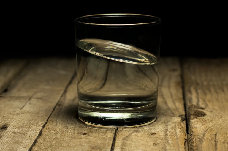 Ett glas med vatten står på ett bord