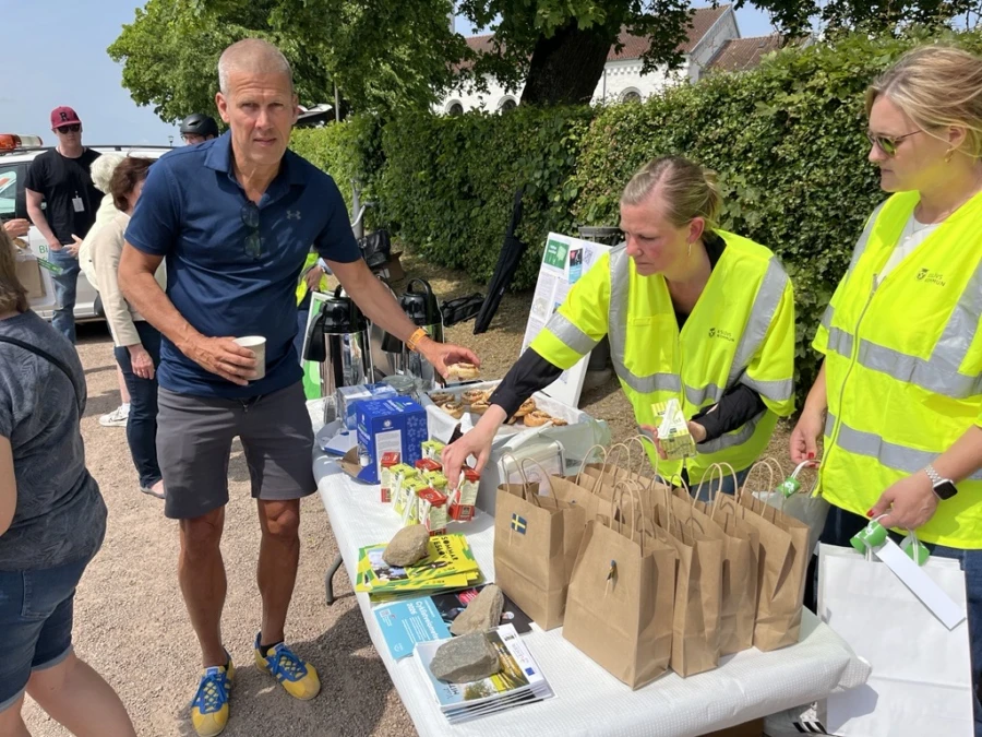 Fika vid ett bord, personer tar en bulle