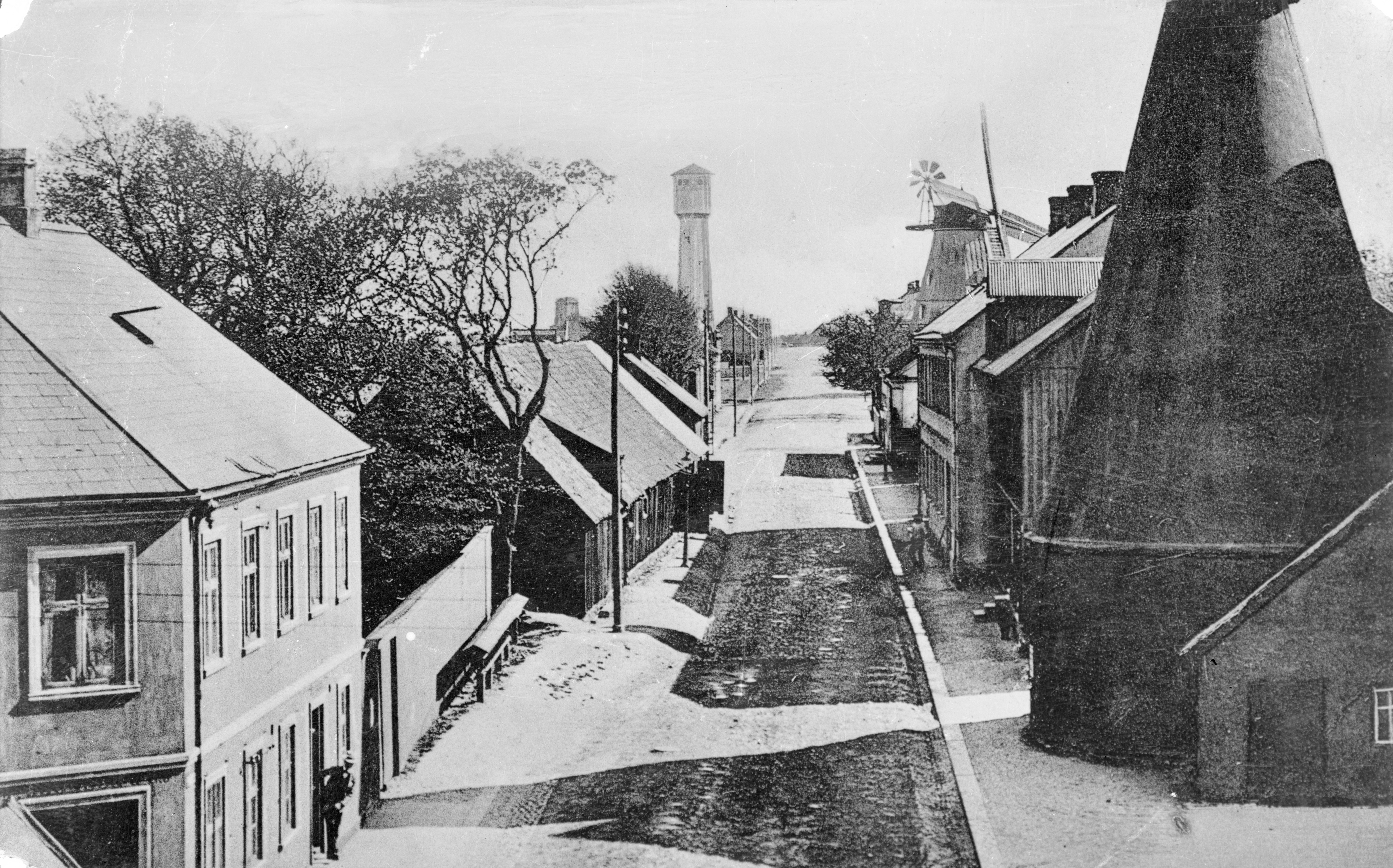 H&auml;r syns vattentornet fr&aring;n ett annat h&aring;ll, s&ouml;derut l&auml;ngs Kvarngatan. Till h&ouml;ger skymtar en torkria, d&auml;r spannm&aring;len torkades. F&ouml;jers bildarkiv.