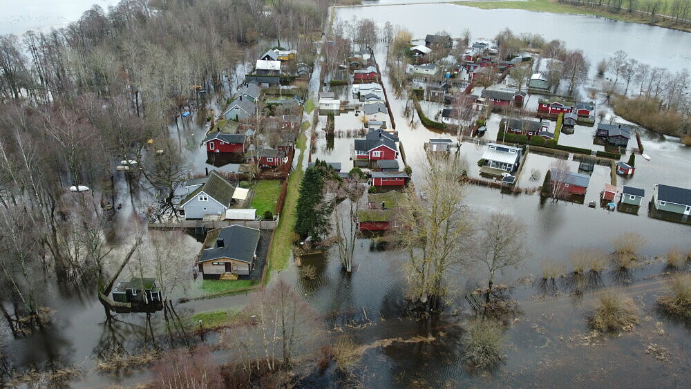 Översvämmat hus- och stugområde med vatten runt alla huse