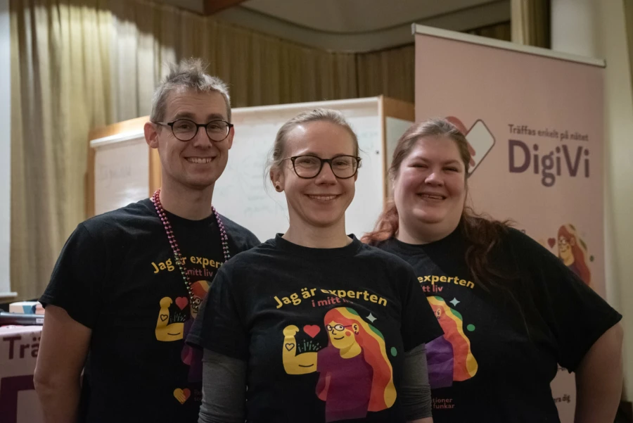 En man och tv&aring; kvinnor st&aring;r bredvid varandra och tittar p&aring; kameran. De alla har p&aring; sig samma t-shirt som visar illustration p&aring; en person med h&aring;ret regnb&aring;gsf&auml;rgat. Ovanf&ouml;r illustrationen st&aring;r texten: "jag &auml;r experten i mitt liv".