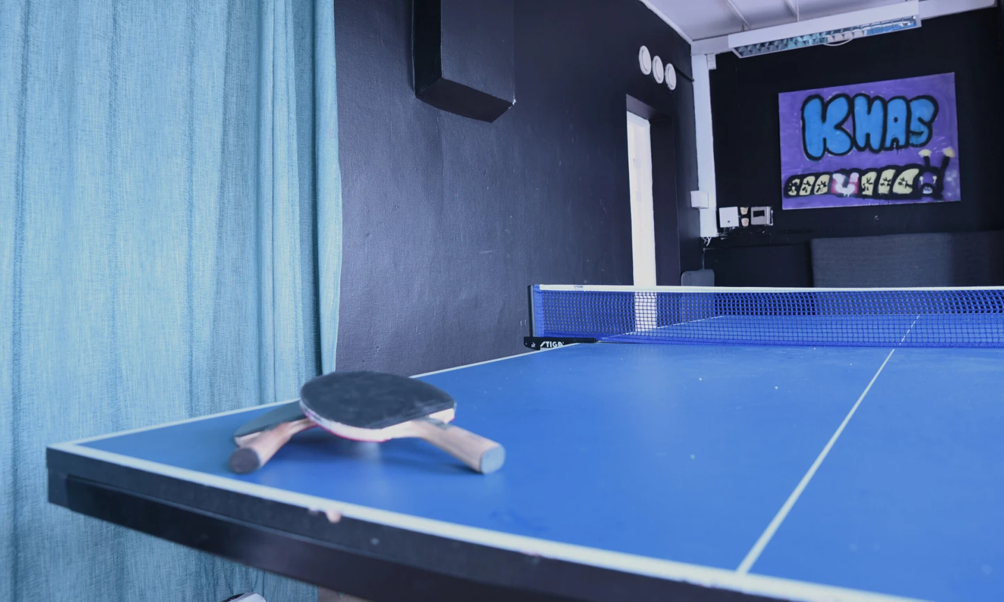 Två bordtennisracket ligger på ett bordtennisbord.