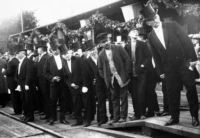 Män i början av 1900-talet som väntar på att första tåget ska anlända till Eslöv.