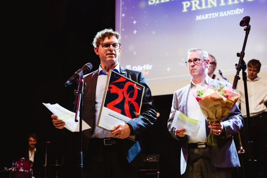 Prisutdelning på scen, två män mottar pris