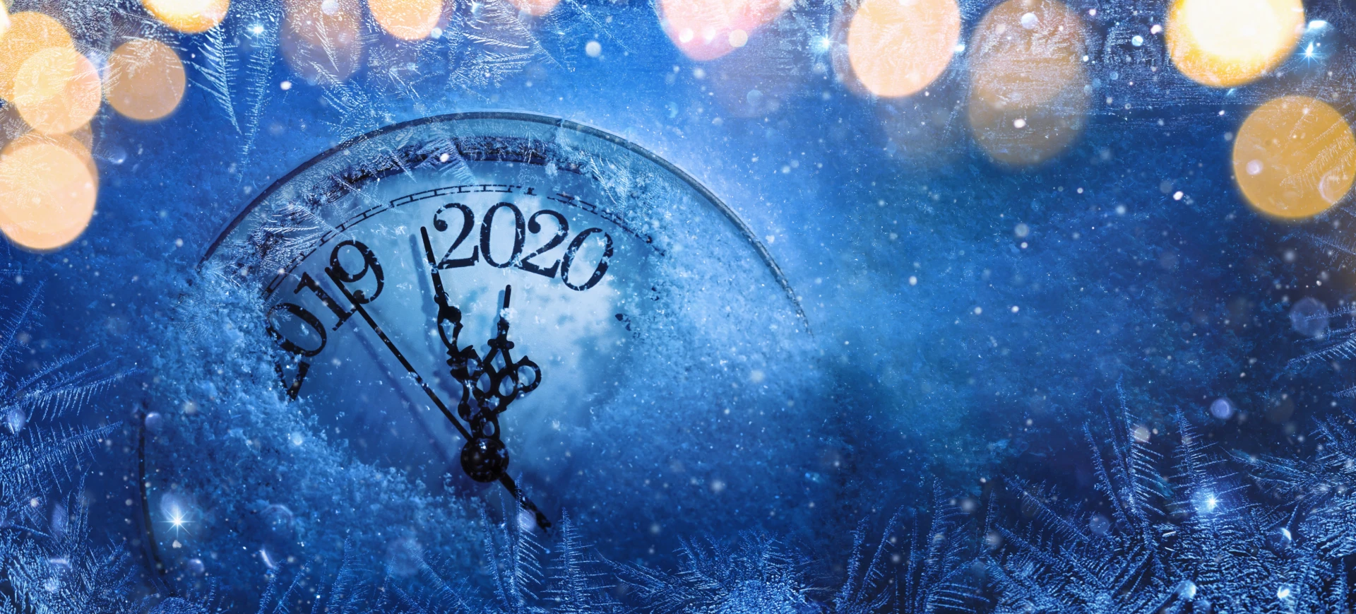 Nyårsbild i blått med klocka som går över från 2019 till 2020-
