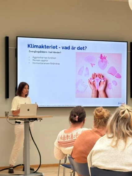 Föreläsning om klimnateriet på jobbet. kvinnlig föreläsare står vid bildskärm