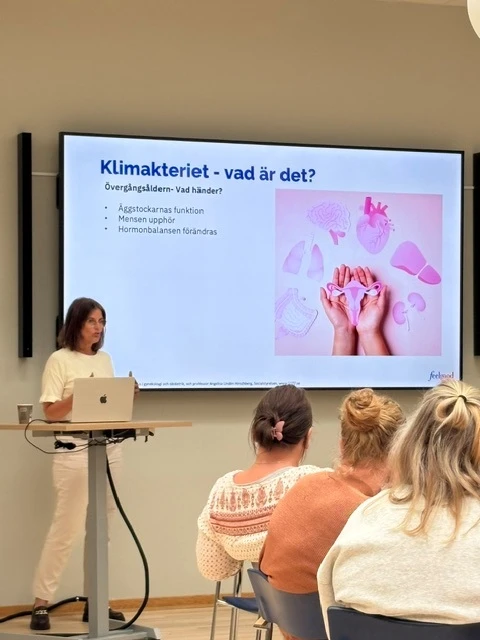 Föreläsning om klimnateriet på jobbet. kvinnlig föreläsare står vid bildskärm
