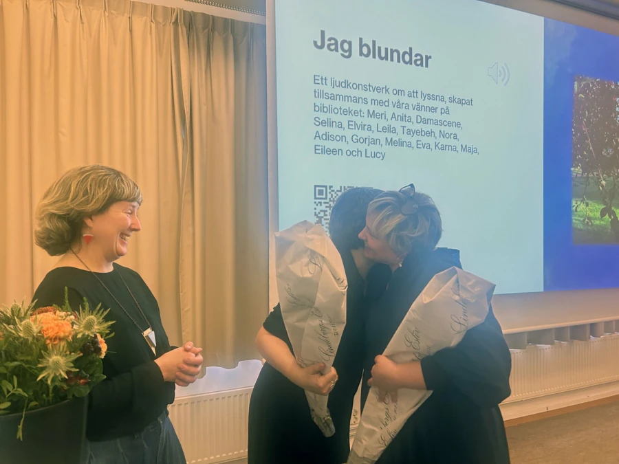 Lucy Cathcart Fr&ouml;d&eacute;n och Eileen Laurie tar emot blommor fr&aring;n SFI-l&auml;raren Karna f&ouml;r sitt arbete under h&ouml;stens konstn&auml;rsresidens.