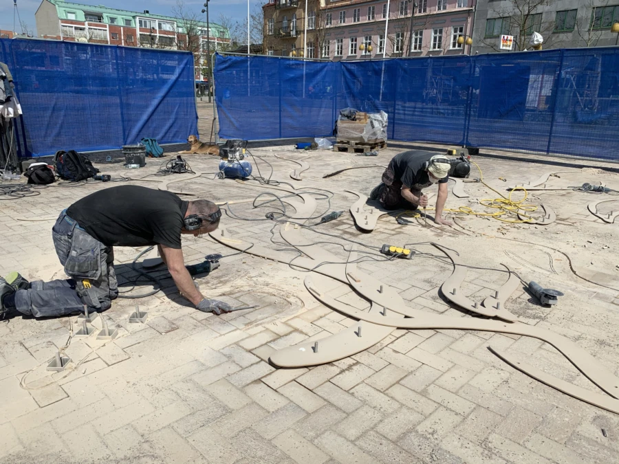 Stenkonstnär Marc Rizell och stenhuggare Rob Krieger fräser ut skulpturens former.