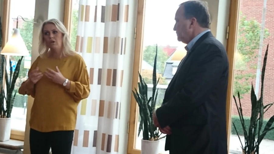 Socialminister Lena Hallengren och statsminister Stefan L&ouml;fven framf&ouml;r ett f&ouml;nster i Medborgarhuset.