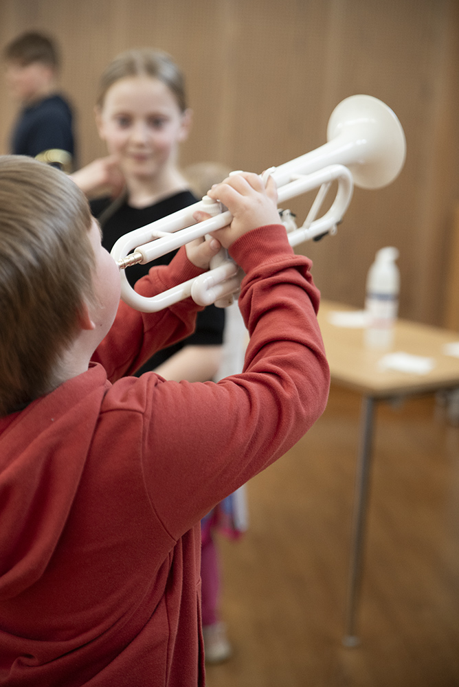 Barn spelar trumpet.