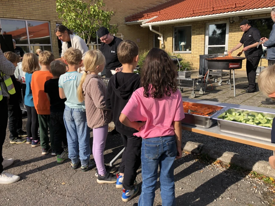 Barnen h&auml;mtar sin mat i solskenet.