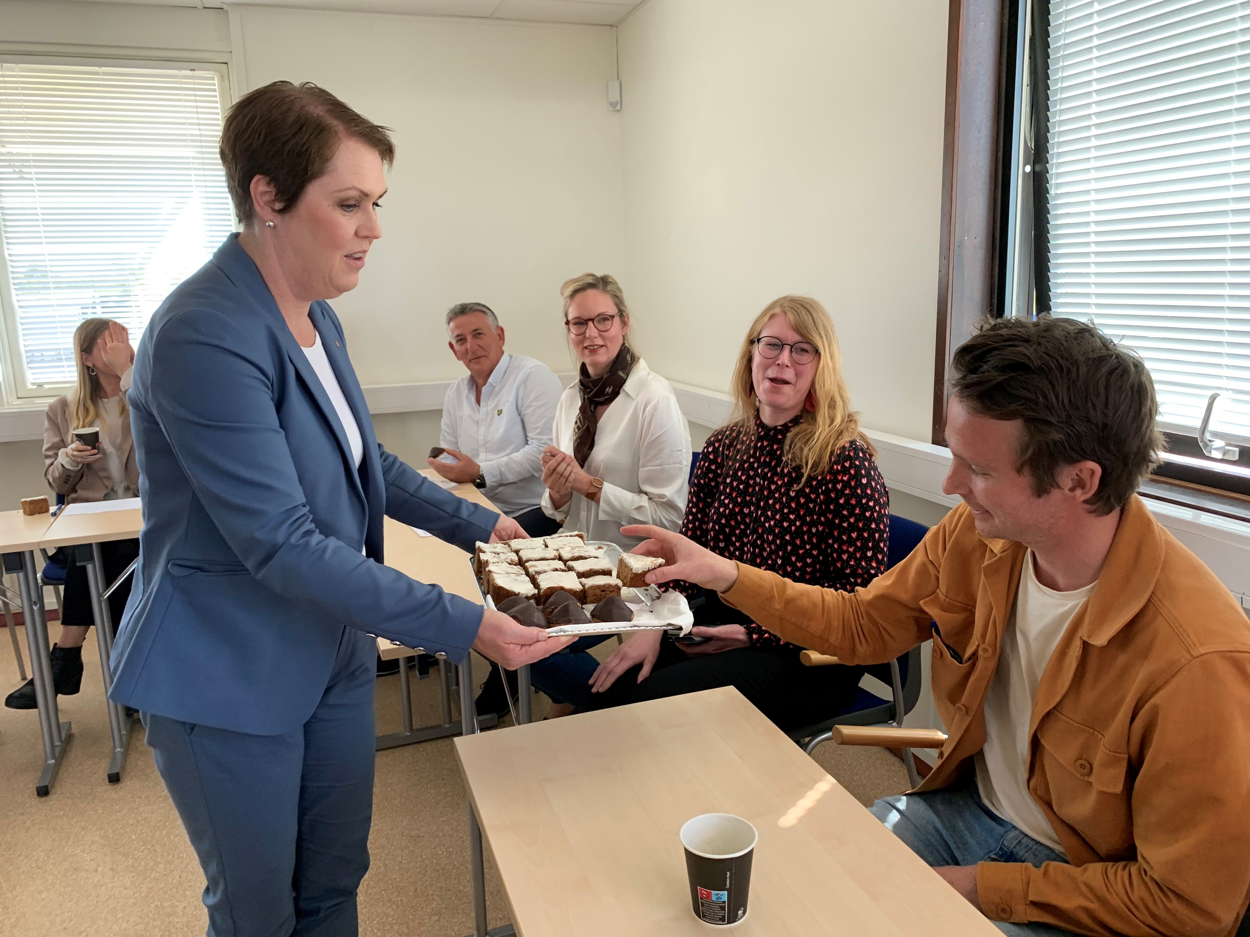 Socialminister Lena Hallengren tog själv kakfatet och bjöd runt bland medarbetarna inom socialtjänsten.