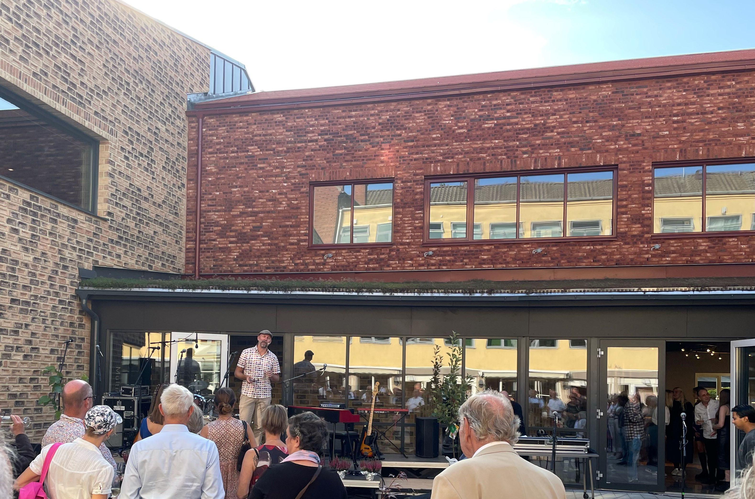 Man underh&aring;ller framf&ouml;r Multihuset. M&auml;nniskor st&aring;r framf&ouml;r med ryggen mot kameran.