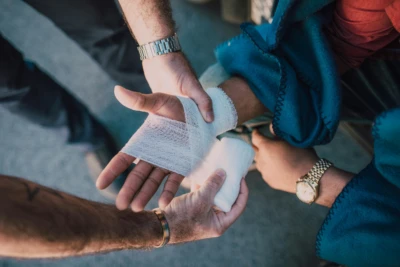 En person lägger ett bandage runt en hand