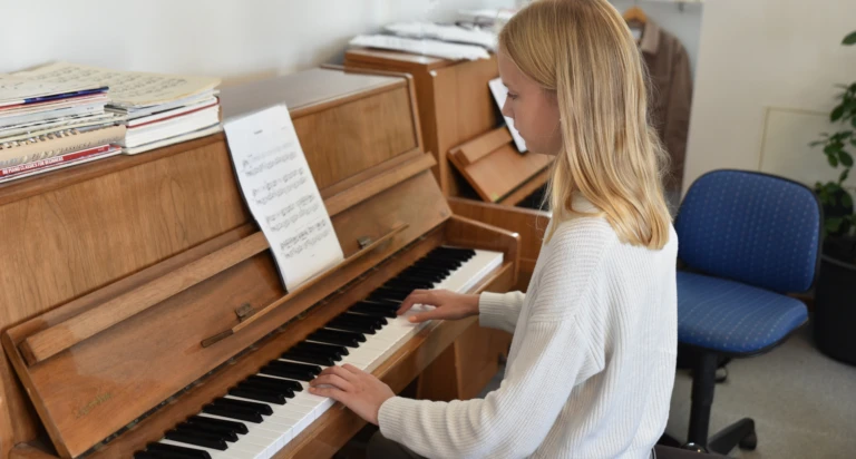 Flicka spelar piano efter noter