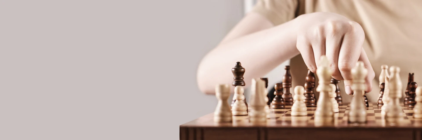 En hand som flyttar en schackspelare på spelplanen