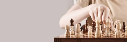 En hand som flyttar en schackspelare på spelplanen