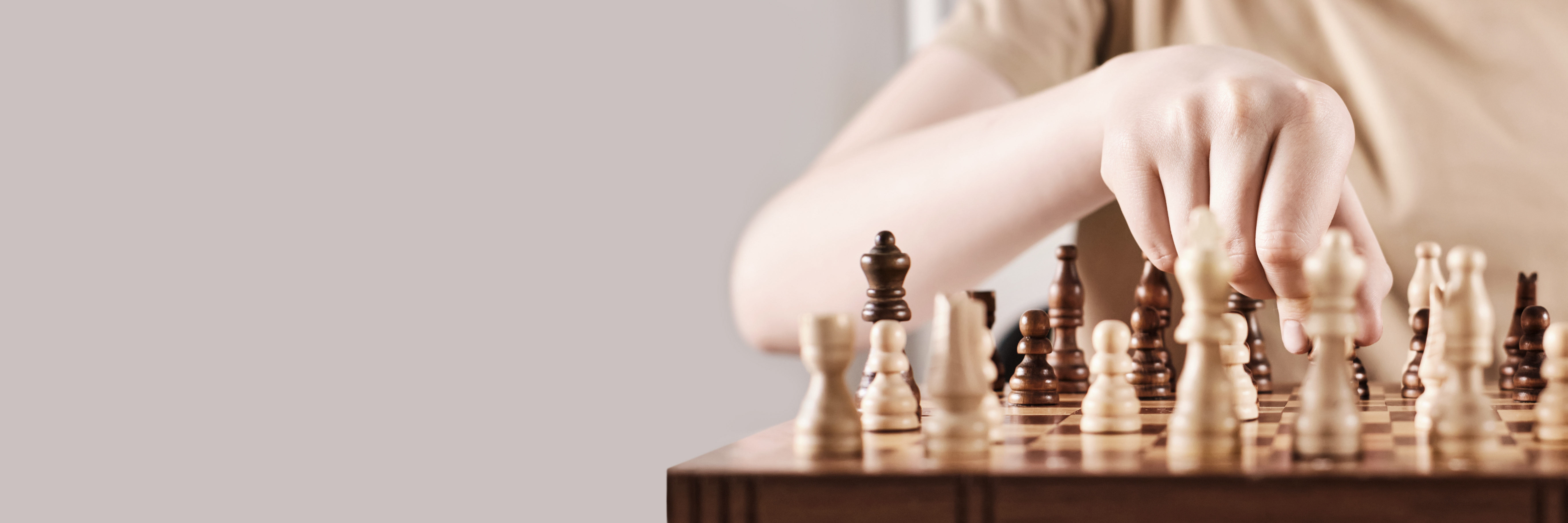 En hand som flyttar en schackspelare på spelplanen