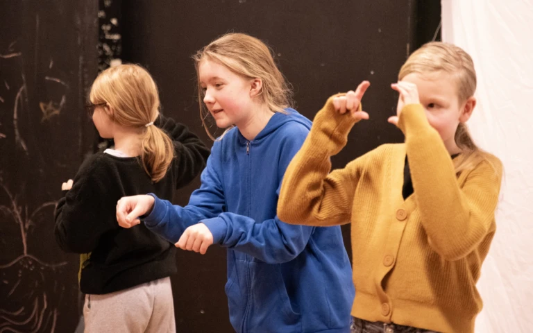 Tre flickor i mellanstadie-åldern spelar teater